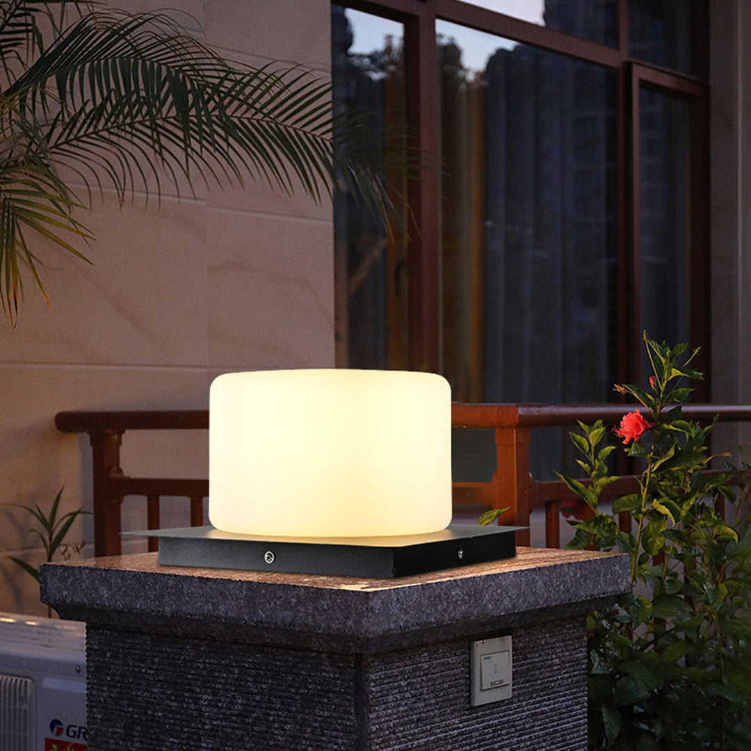 Silver Metal Table Lamp cubic outdoor light with minimalist design creating ambient illumination on textured stone platform