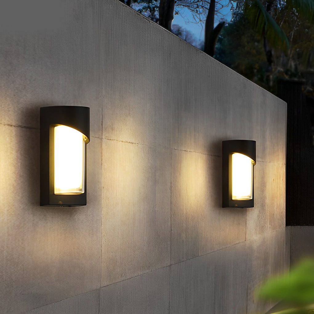 Black outdoor wall light with curved design illuminating modern exterior wall.