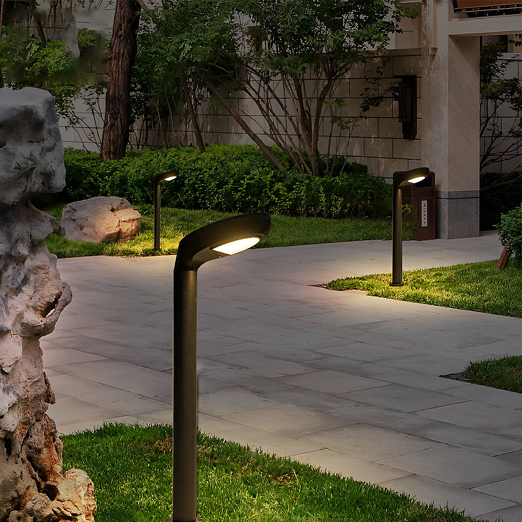 Curved bollard light guiding a garden path with warm downward lighting.