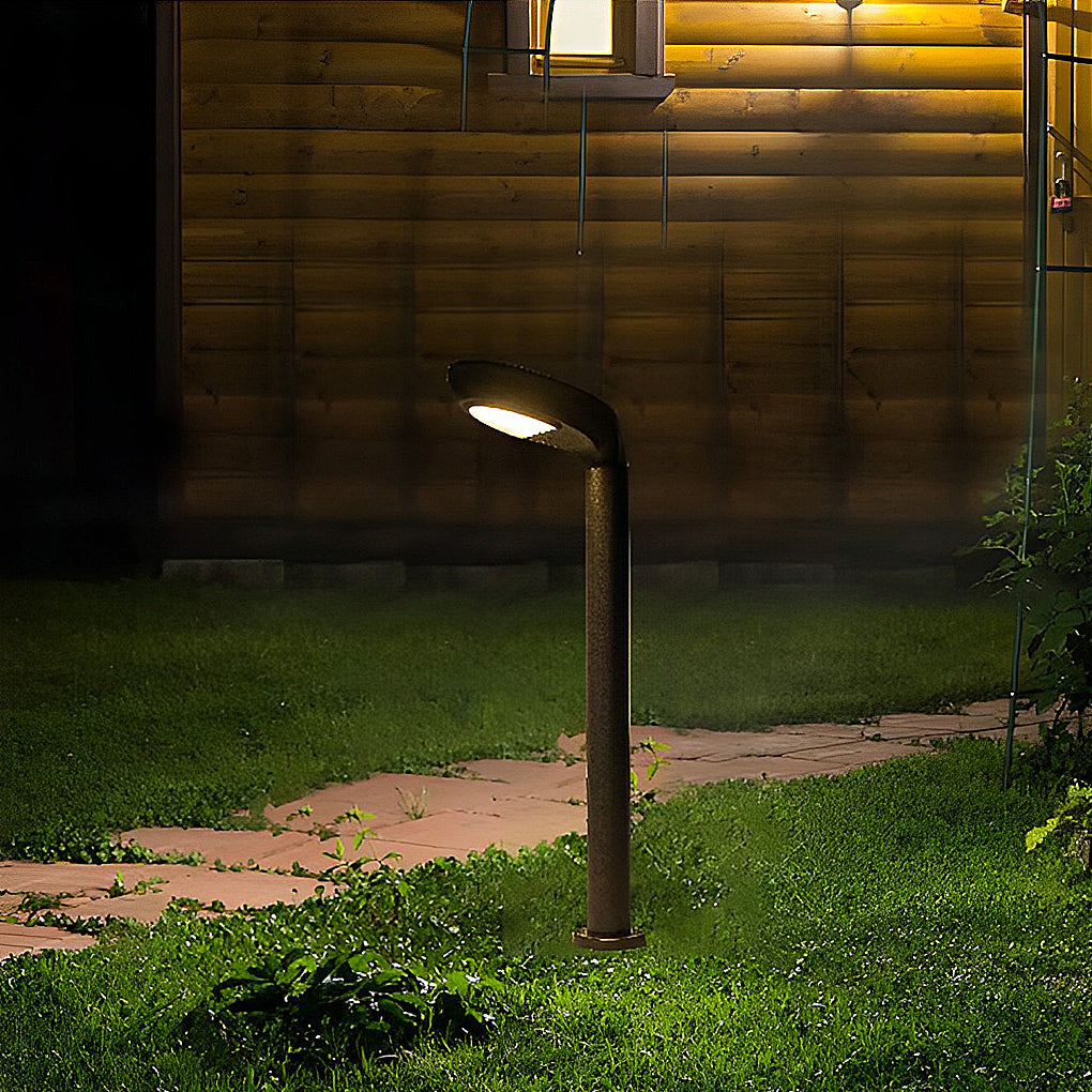 Curved bollard light beside a wooden exterior wall at night.
