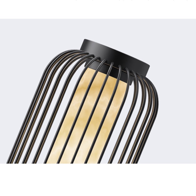 Lantern metal outdoor light with curved design, providing warm glow beside modern water feature.
