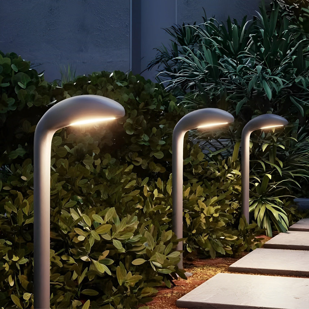 Curved path light providing soft illumination along a stylish outdoor walkway.