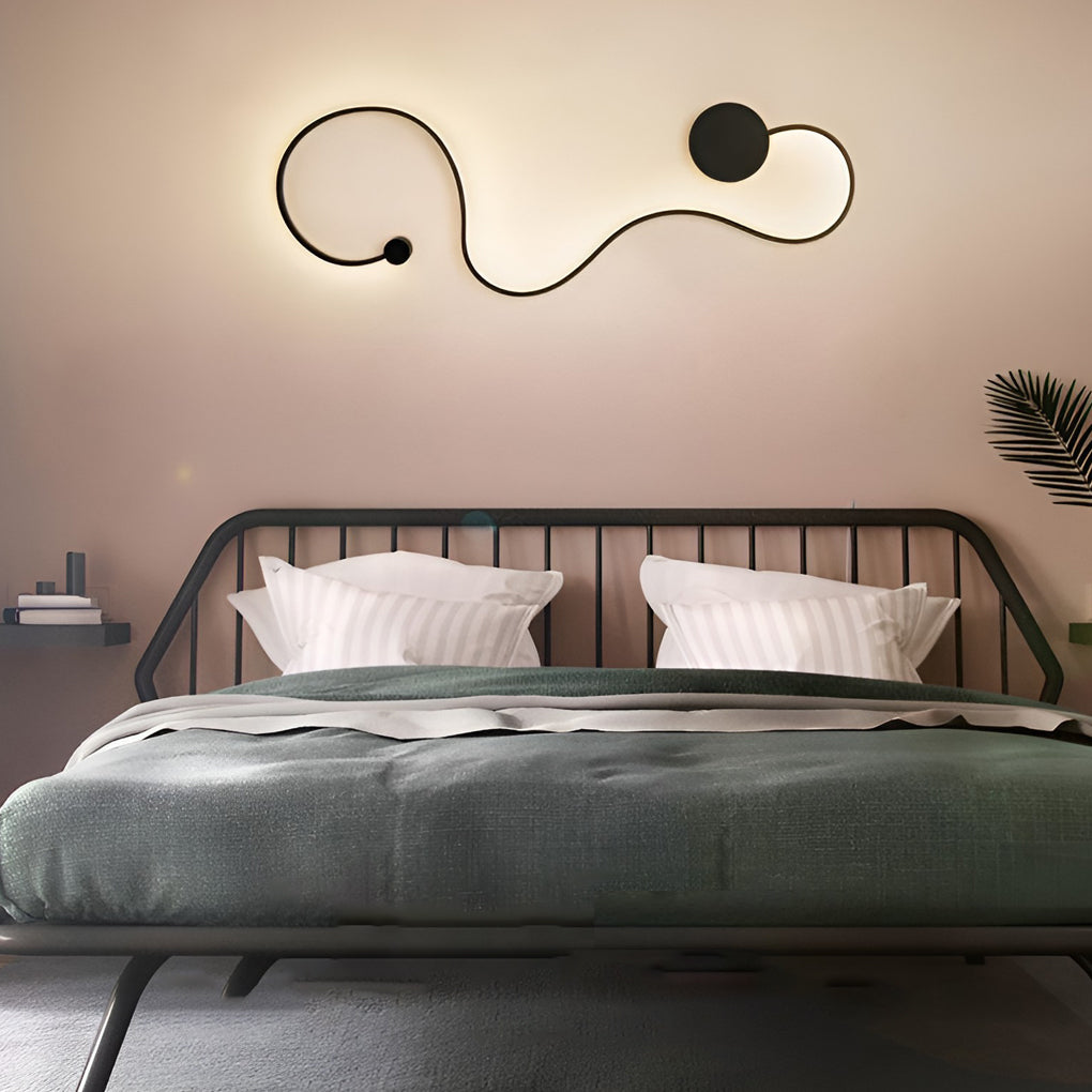 Curved wall sconce mounted above the bed headboard in a modern bedroom.