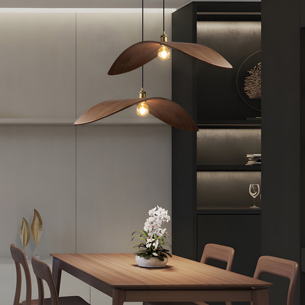 Curved wood pendant light with a unique design, hanging in a stylish dining room.