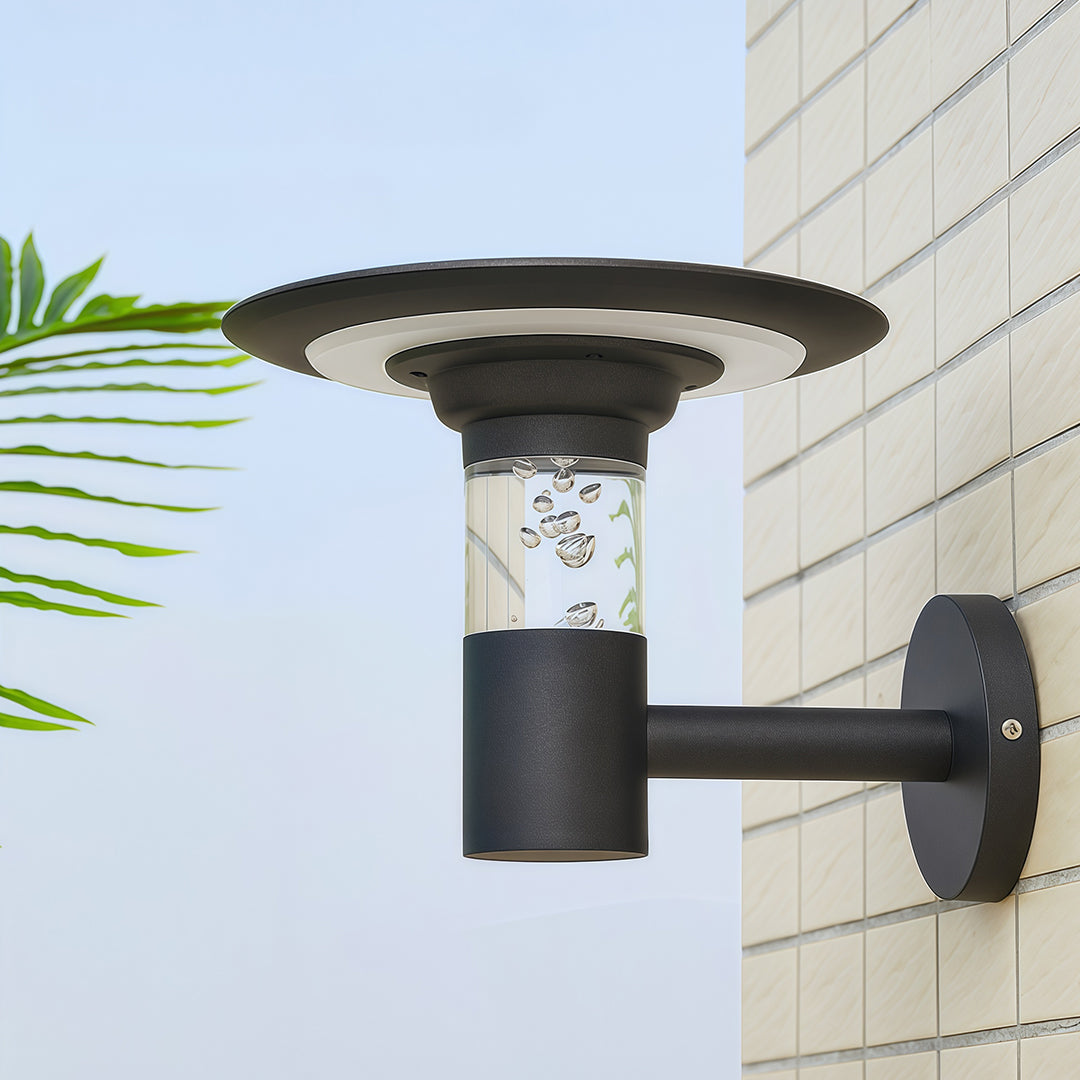 Daytime view of the modern solar outdoor wall lighting fixture with bubble glass, mounted on a tiled wall.