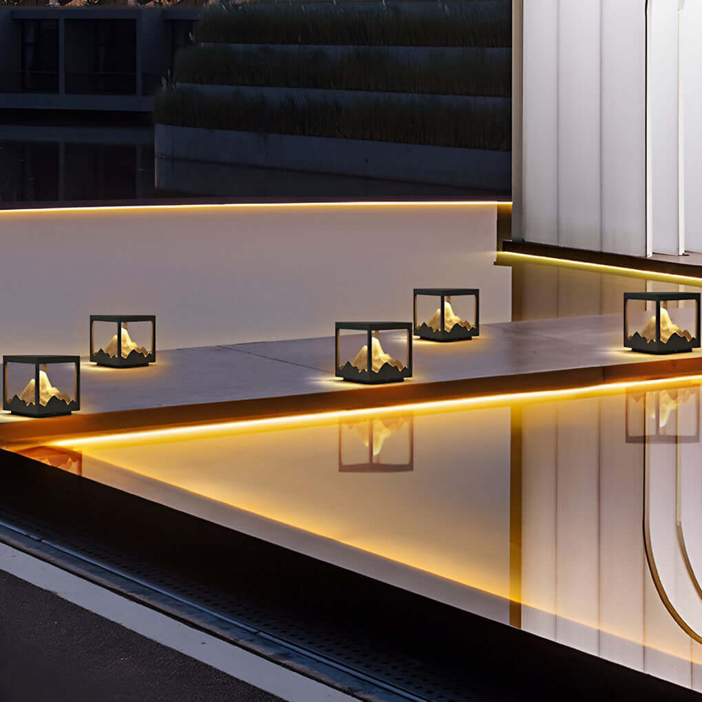 Decorate pillar light with mountain design, providing ambient light in a garden.