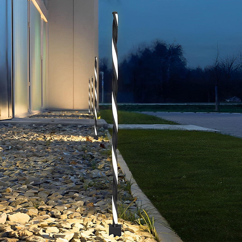 Decorative garden lighting placed beside a building wall accenting outdoor architecture after dark.