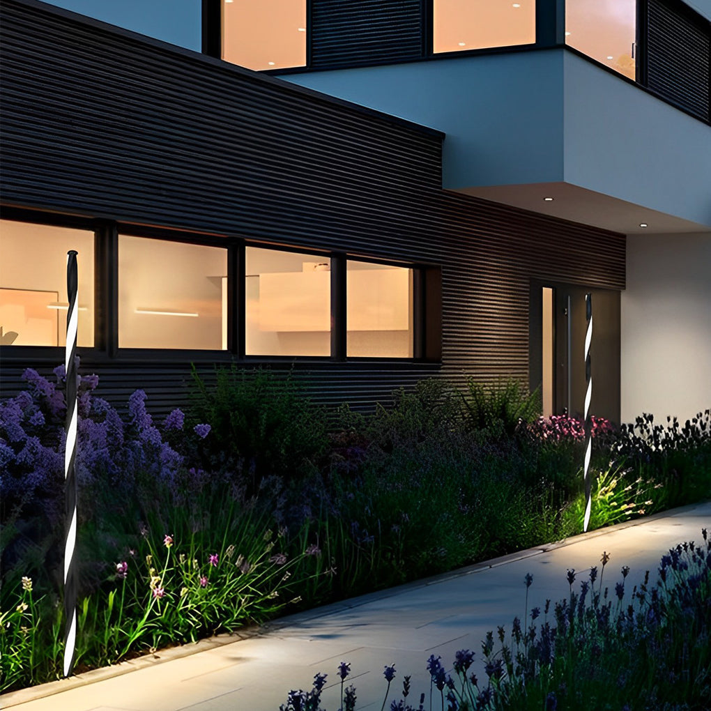 Decorative garden lighting illuminating planting beds near a modern residential facade.