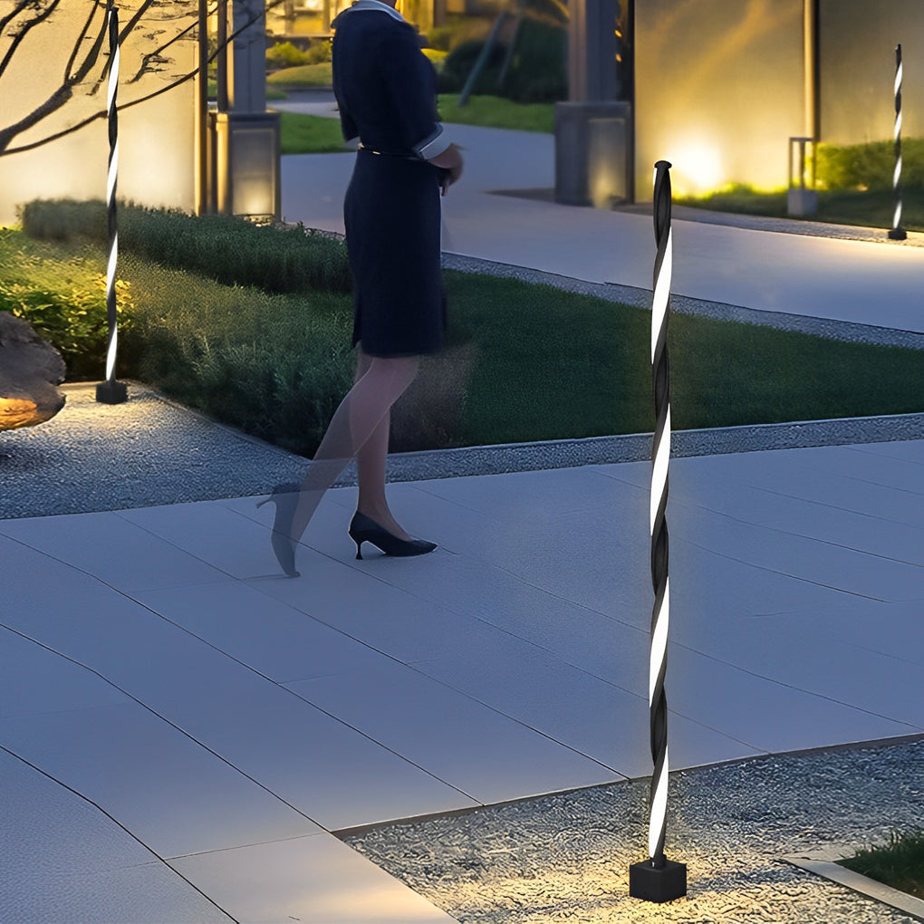 Unique Minimalist LED Waterproof Black Solar PowDecorative garden lighting used near a walkway with people passing, enhancing safety and ambiance.ered Lawn Lights Path Lamp - Dazuma