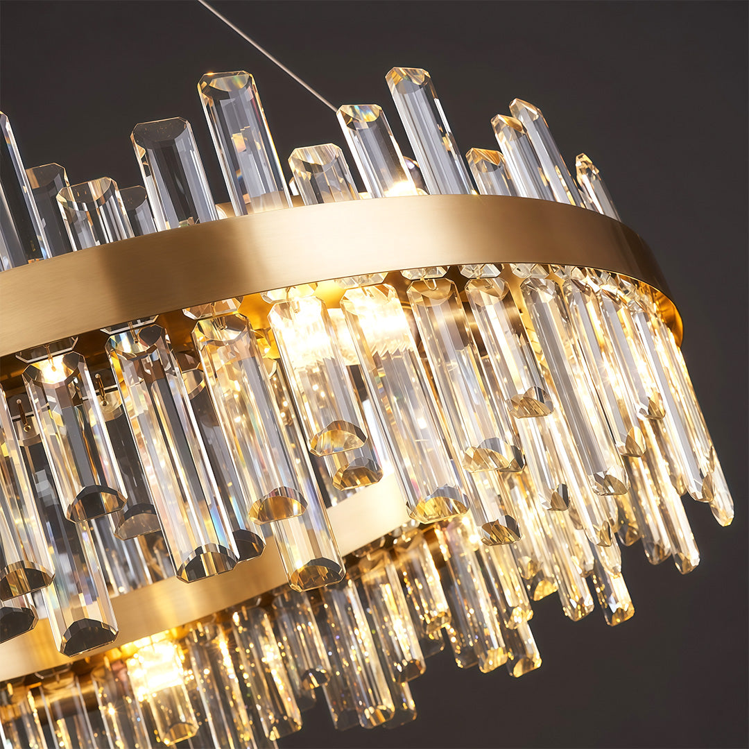 Modern luxury crystal chandelier close up showcasing brass frame and crystal glass rod detail.