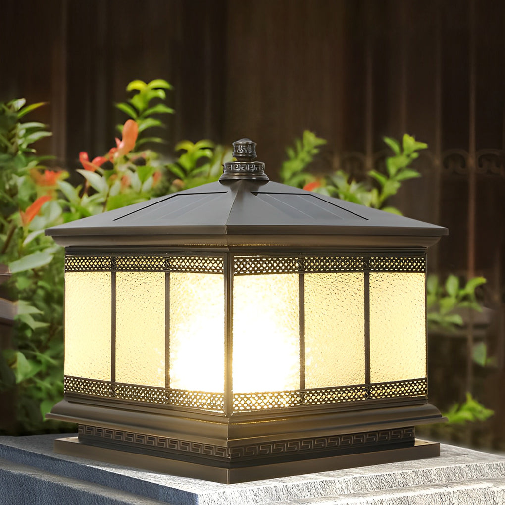 Decorative waterproof pillar light installed on a garden wall beside lush landscaping.