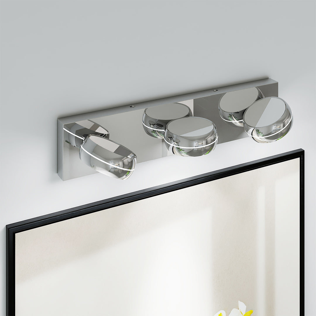 Designer chrome bathroom vanity light featuring glass shade chandelier aesthetic above black-framed mirror in modern bathroom.