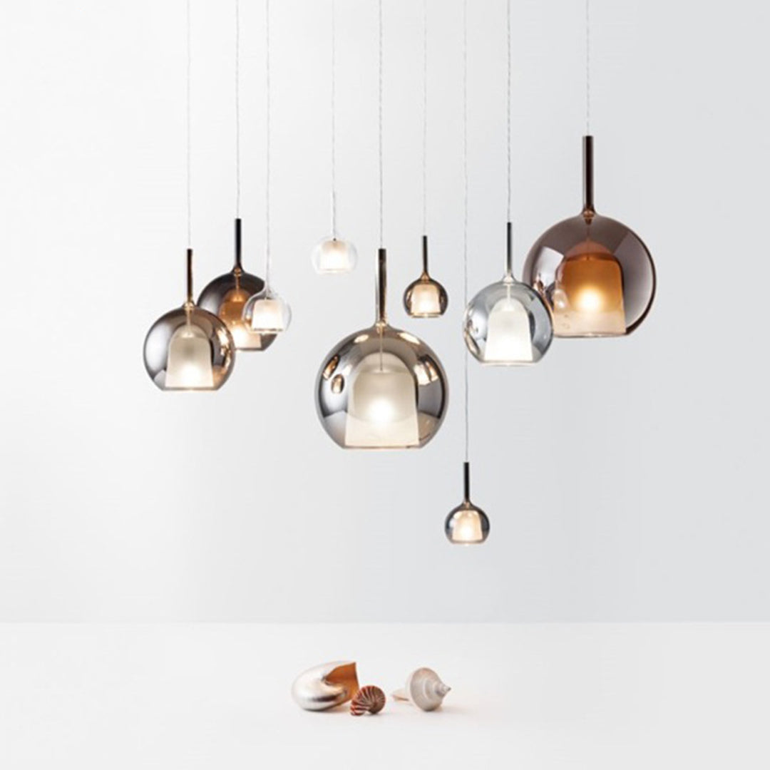 Designer glass ball pendant lights arrangement with copper and chrome finishes against white wall
