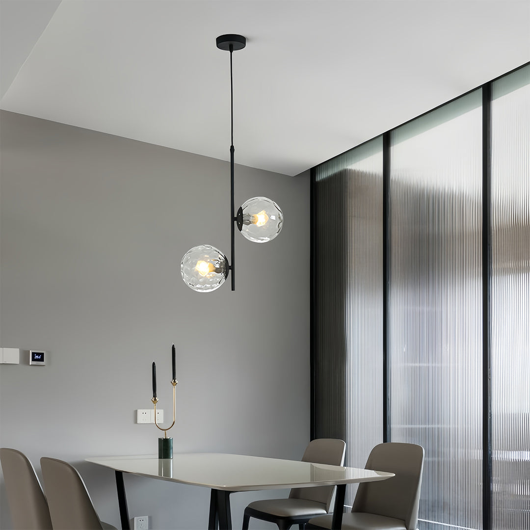 Designer glass hanging pendant lights in luxury bedroom with gold accents and sophisticated decor elements