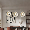 Set of statement pendant light with teardrop forms hanging elegantly above a dining table.