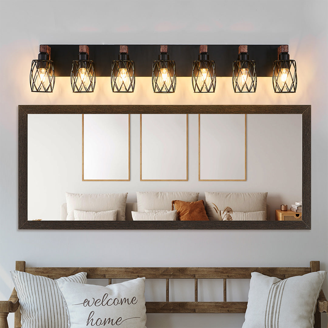 Black vanity bathroom light with four bulbs, installed above a double sink vanity with decorative elements.