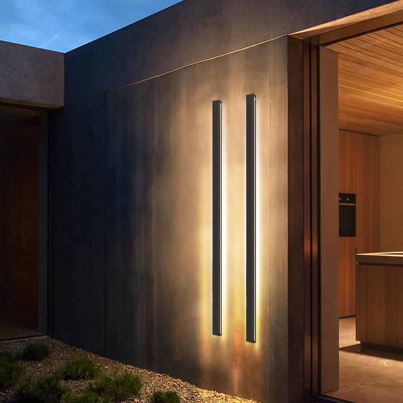 Double vertical linear outdoor wall sconce, creating symmetrical lighting on a modern building facade.