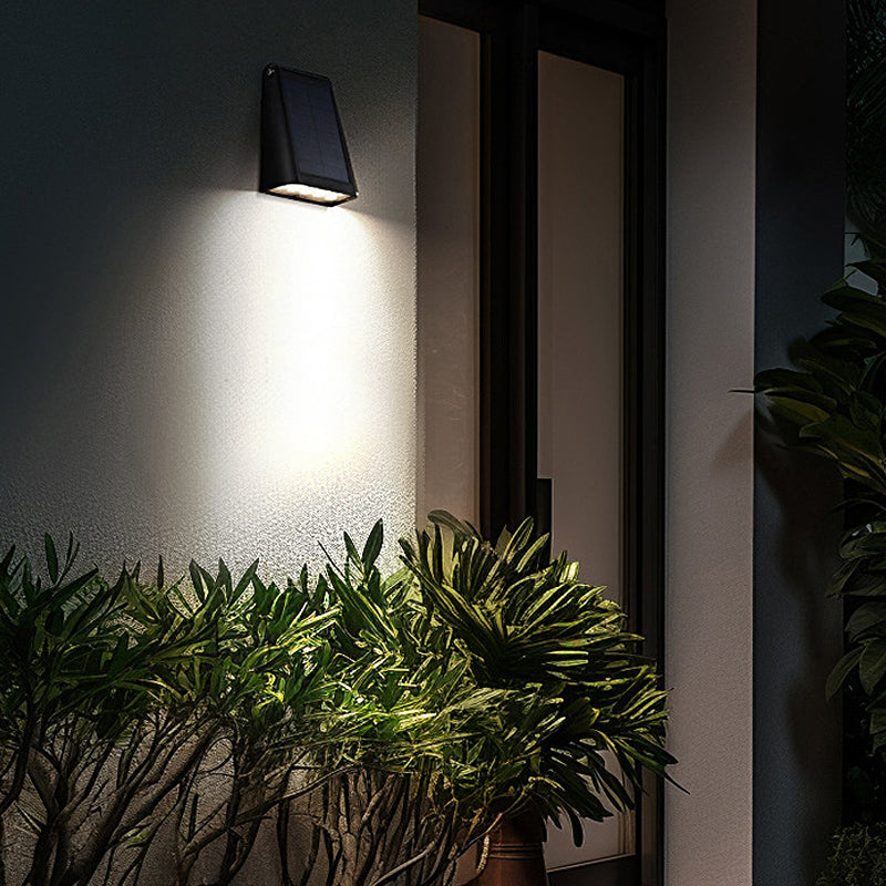 Down light wall sconce lighting a modern exterior wall at night.