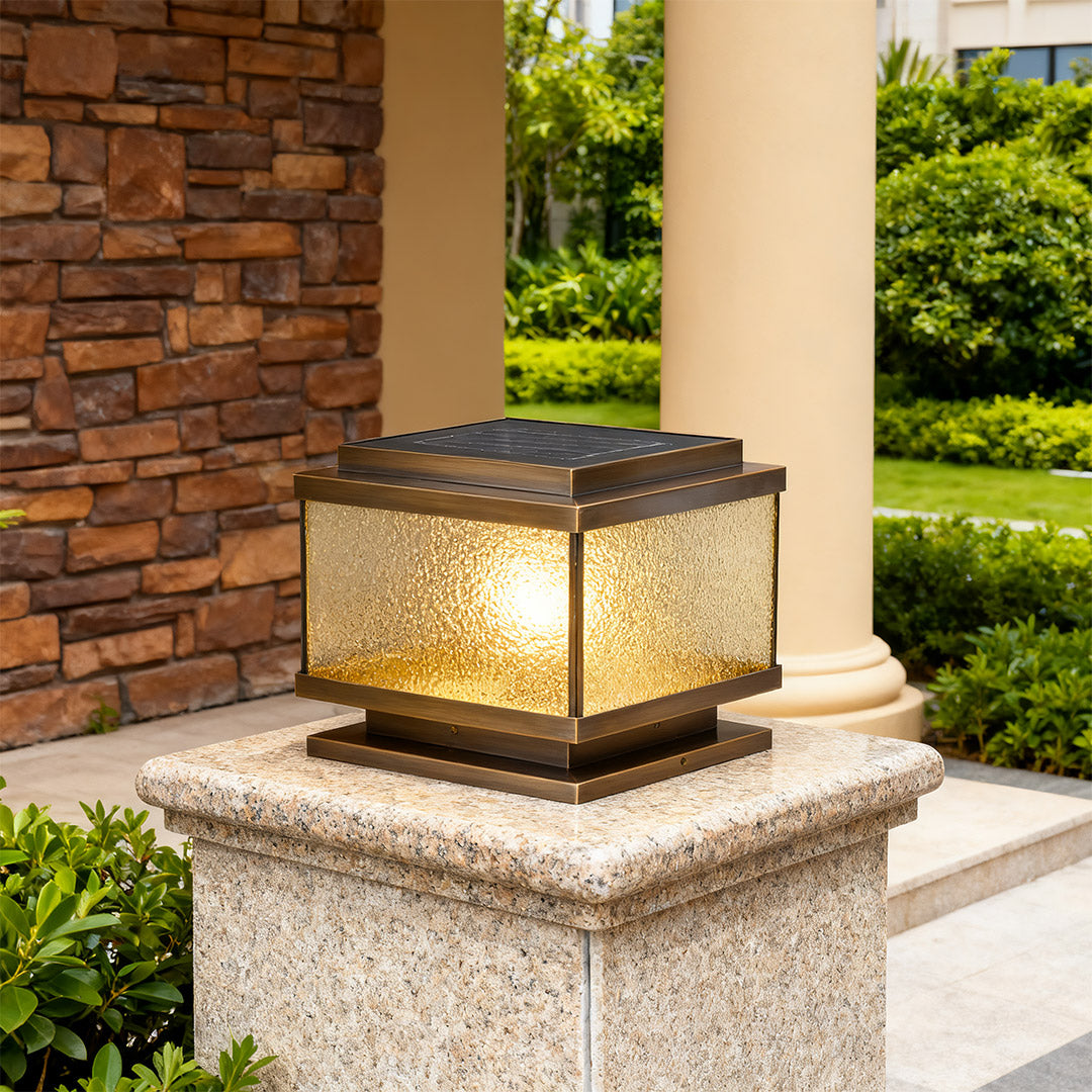 Pair of garden pillar lights mounted on gray concrete posts illuminating modern landscaped driveway.
