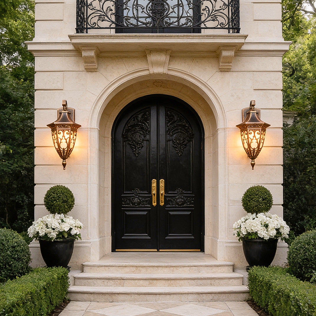Elegant antique art deco wall sconces illuminating a grand entrance, featuring ornate bronze frames and soft ambient lighting.