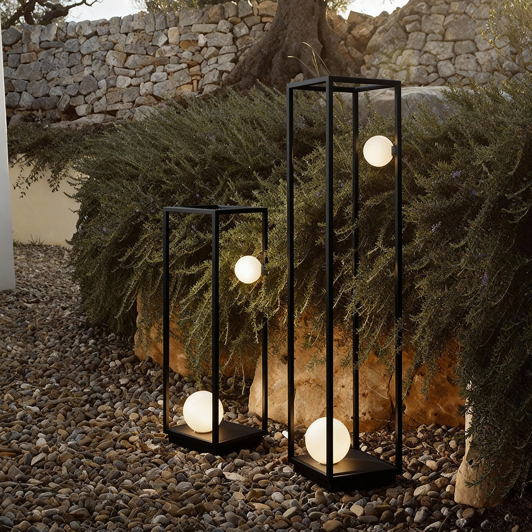Elegant bollard outdoor lights featuring soft spherical bulbs, providing warm illumination along a modern garden.