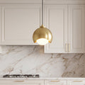 Elegant glass pendant light fixture with a gold crescent dome and a frosted opal glass globe.