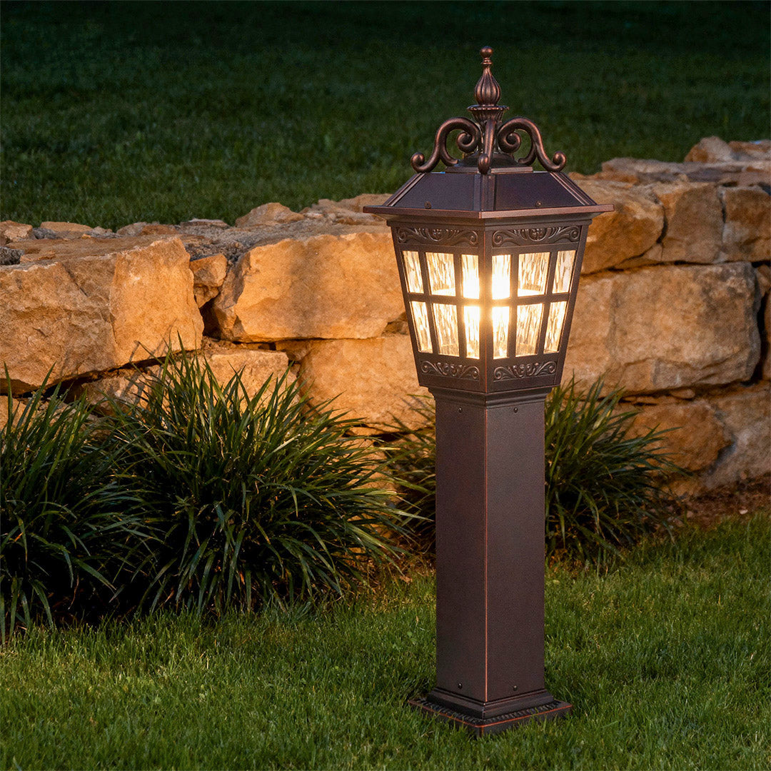 External post lights in a garden with a close-up of the decorative black design.