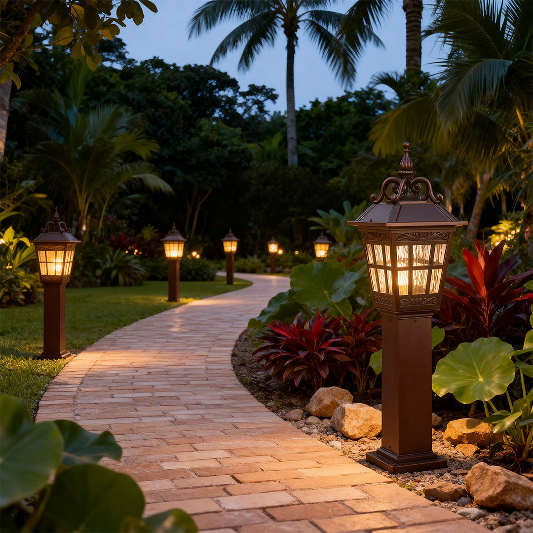External post lights illuminating a tropical garden pathway with palm trees.