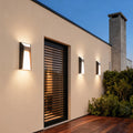Extra large outdoor wall lights providing accent lighting on residential exterior with wood shutters and landscaping