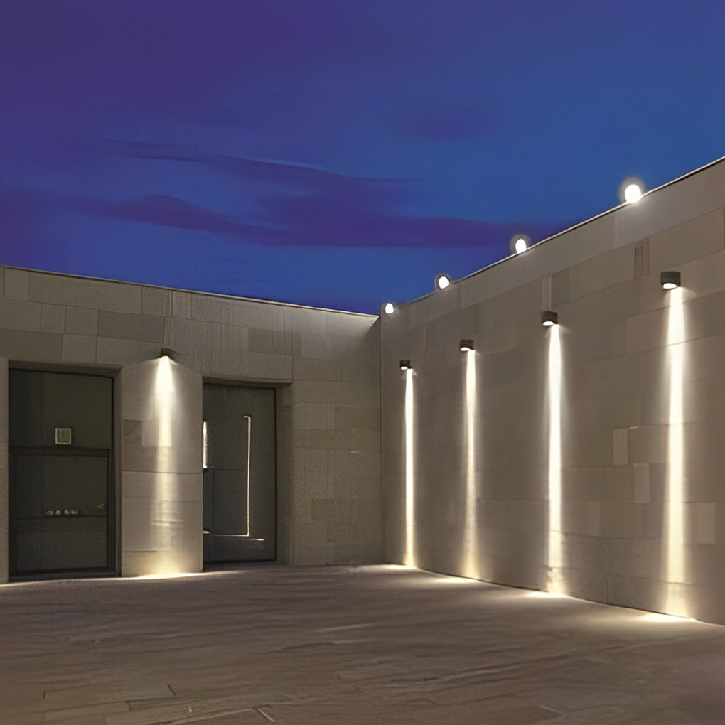 Facade spot lights installed along a courtyard wall, providing uniform exterior lighting for contemporary architecture.