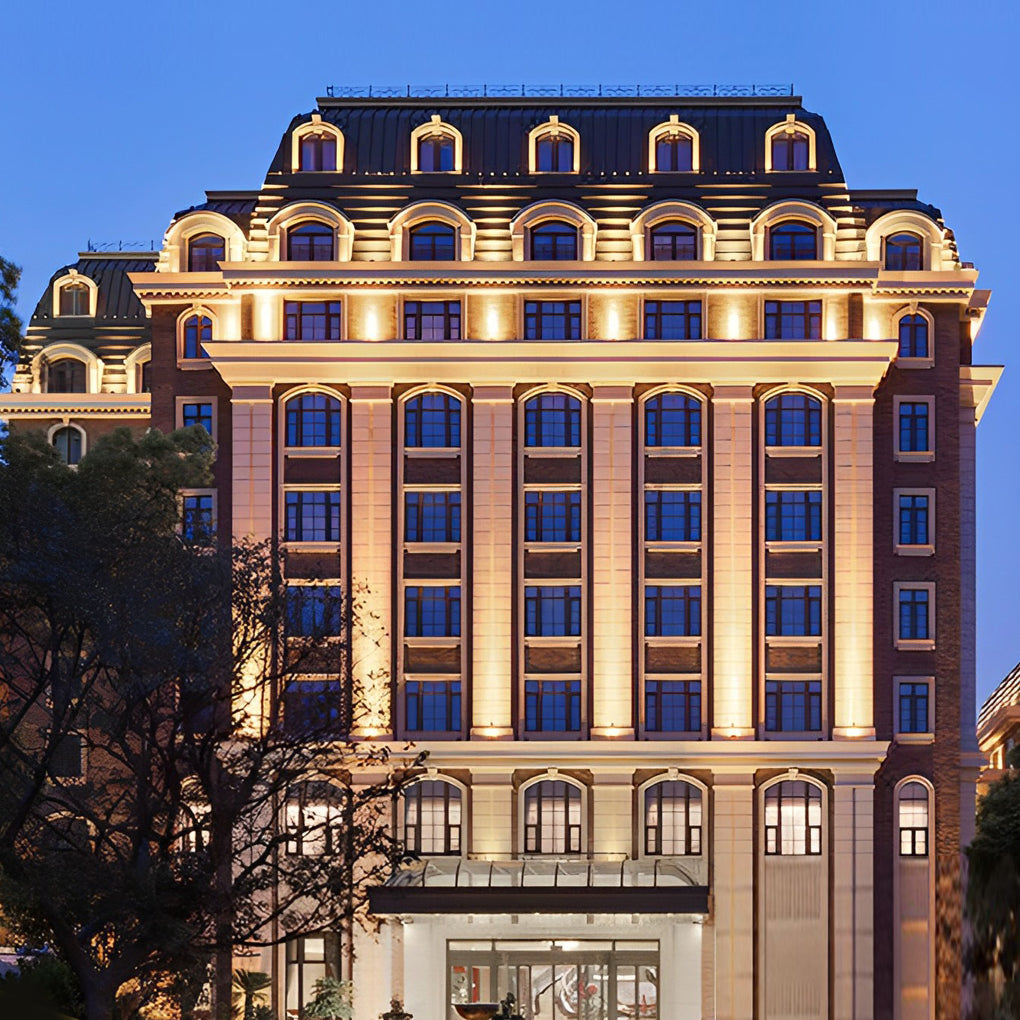 Facade spot lights enhancing a luxury hotel exterior, highlighting windows and architectural details at night.