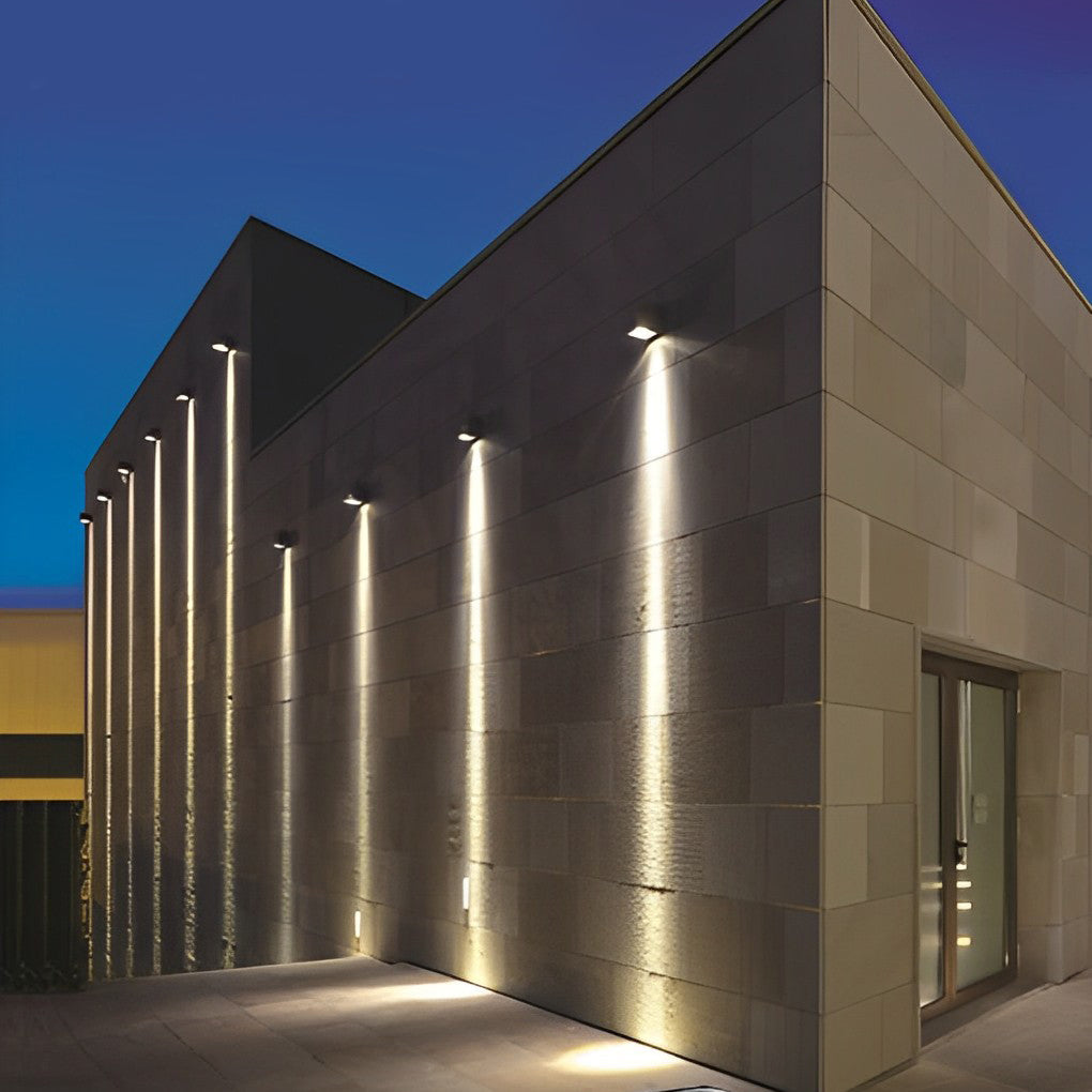 Facade spot lights aligned on a minimalist exterior wall, producing clean linear lighting for modern architecture.