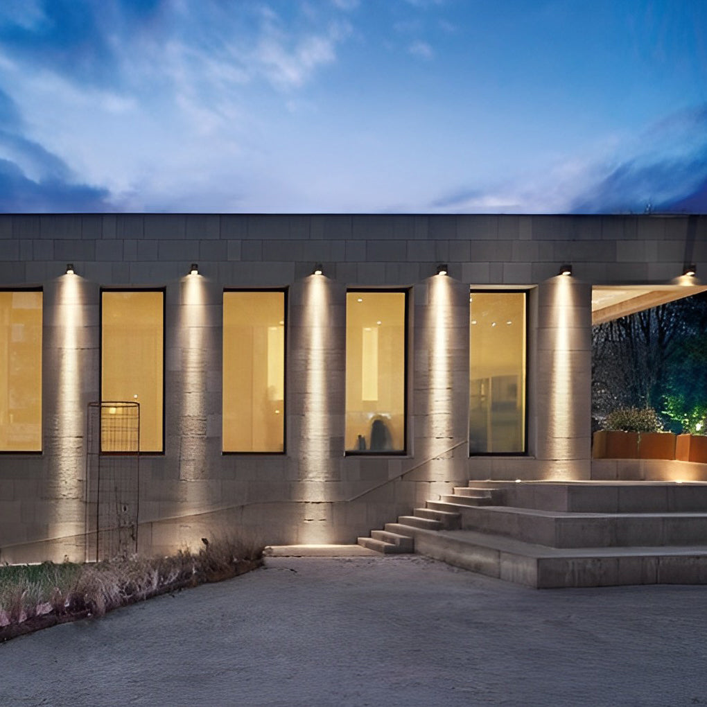 Facade spot lights illuminating a low modern residence, creating soft light patterns along the exterior walls.
