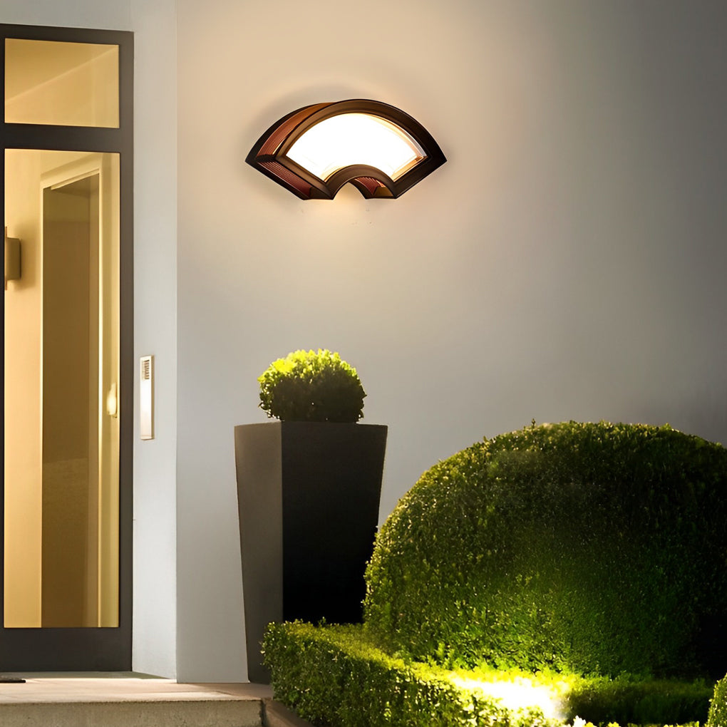 Fan shaped wall sconce with a sleek black and wood finish, enhancing an outdoor patio.