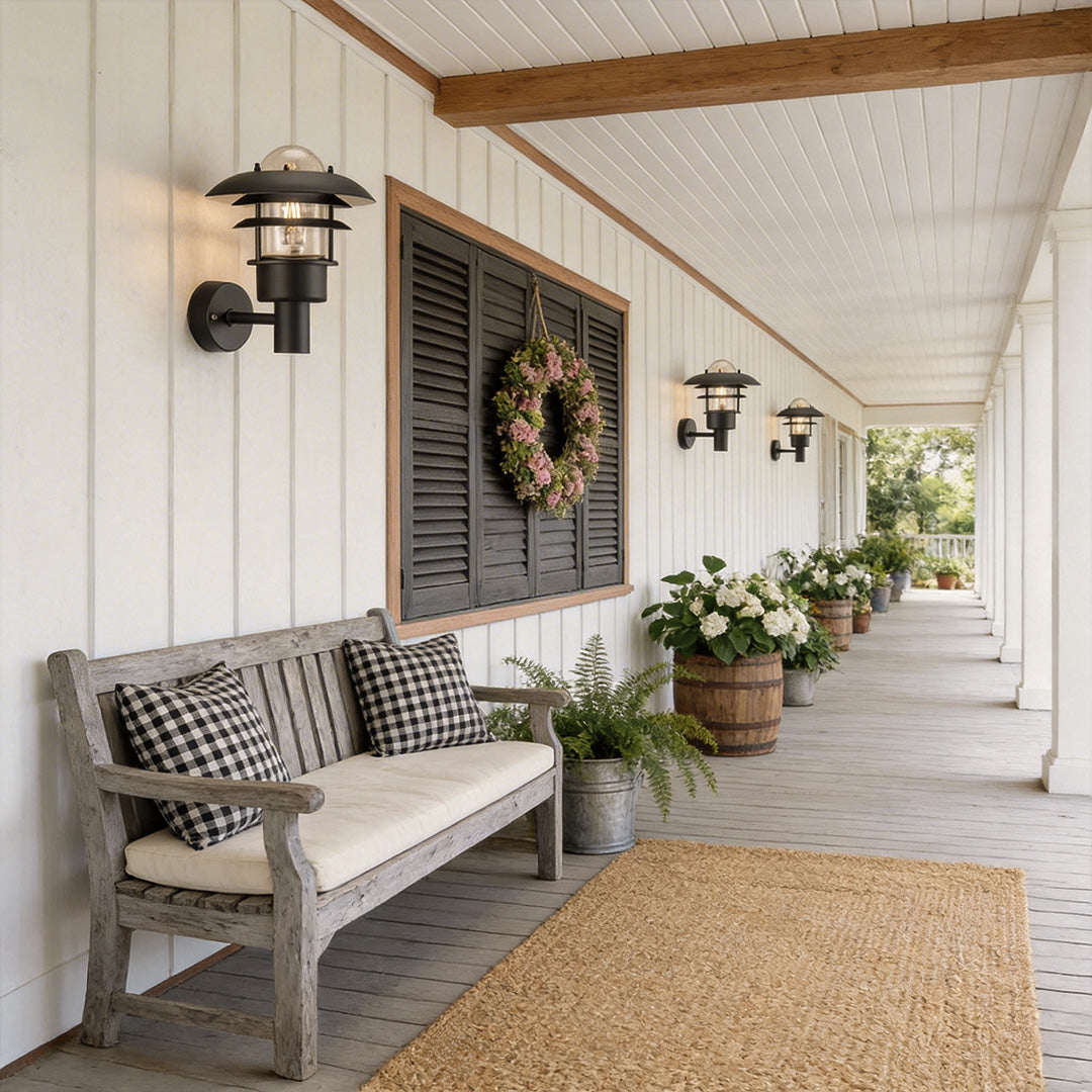 Farmhouse outdoor sconce with a rustic design, enhancing a white porch seating area.