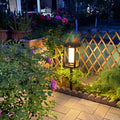 Colorful flower garden pathway enhanced with warm LED lantern lighting and decorative trellis elements