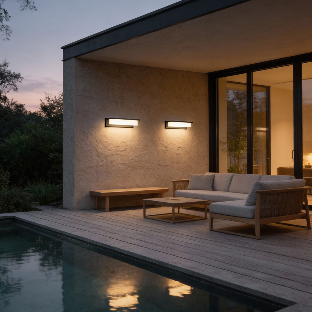 Front porch light fixtures illuminating outdoor patio area at dusk.