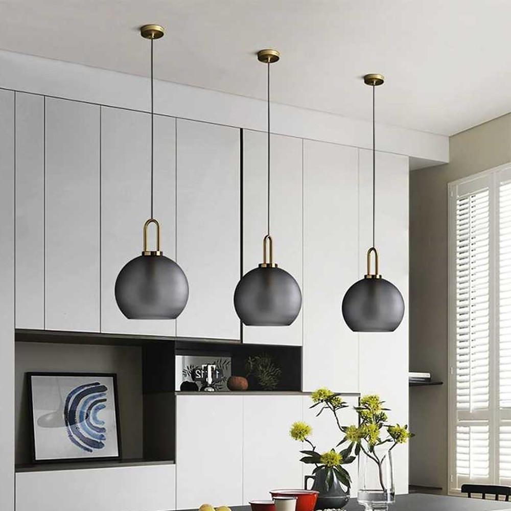 Frosted glass mini pendant lights casting a gentle glow in a chic living room corner.