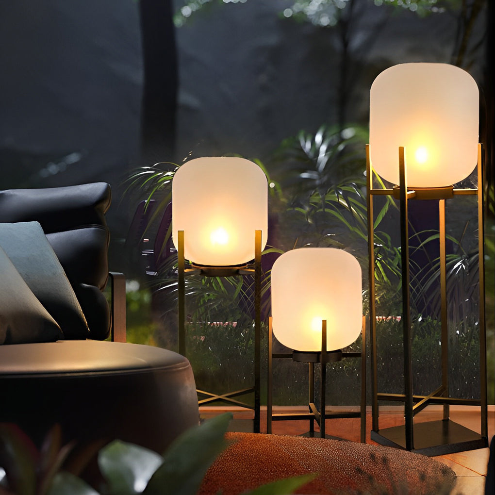 Outdoor standing light with frosted shade and black frame in contemporary outdoor lounge area.