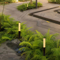 Modern garden pathway illuminated by led bollard garden lights casting soft warm light across curved walkway.