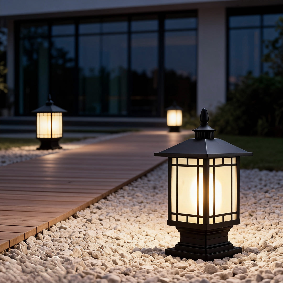 Low-profile street light pillar lighting a garden pathway at night.