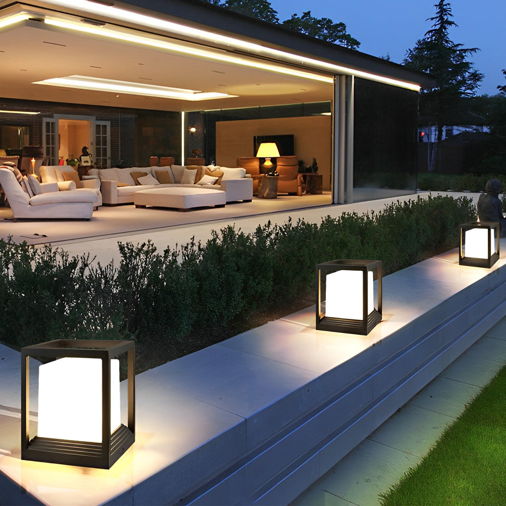 Garden pedestal lights illuminating garden pathway with lush greenery.