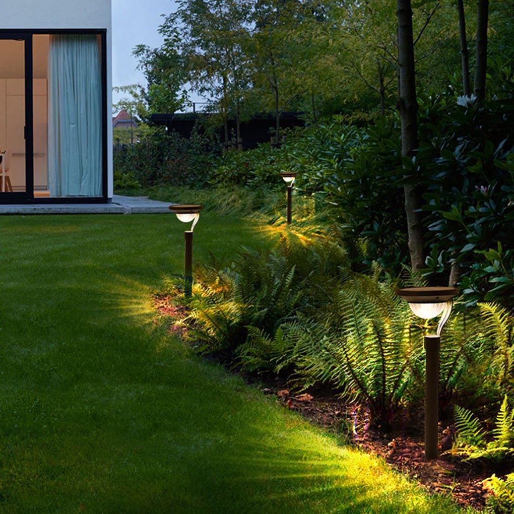 Garden stake solar lights illuminating a garden bed with decorative rocks.