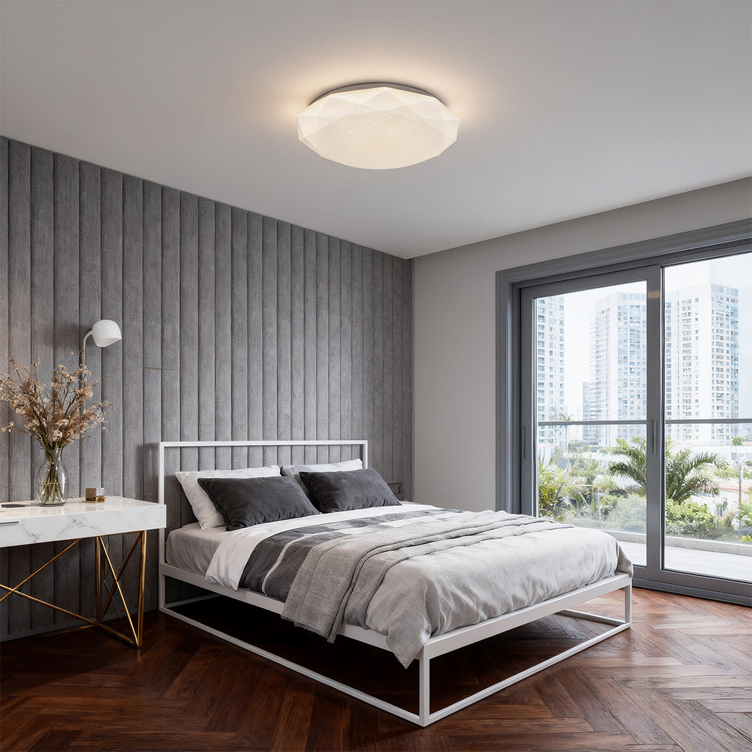 Stylish geometric ceiling light brightening a minimalist gray bedroom interior.