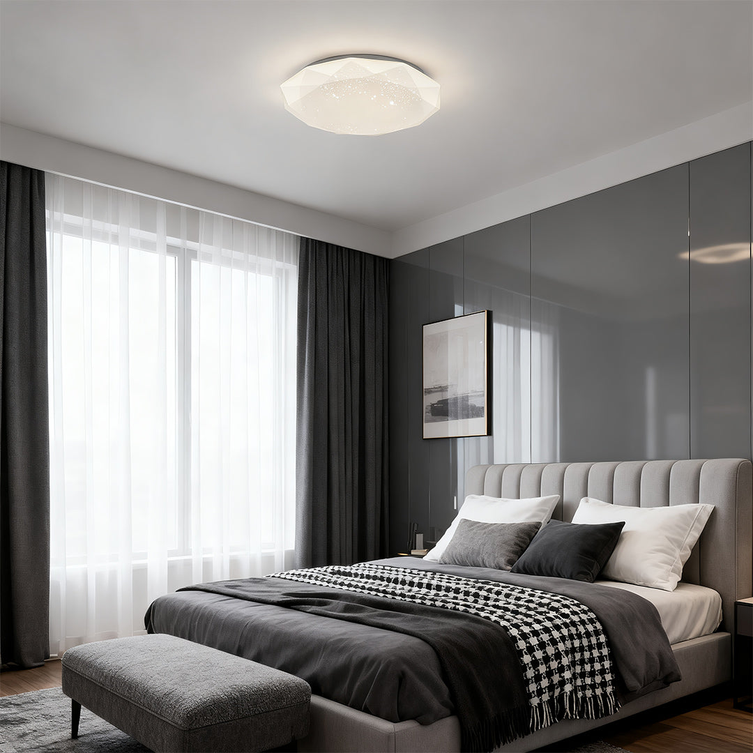Geometric flush mount ceiling light installed in a modern gray bedroom with large window lighting.