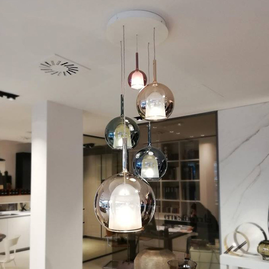 Glass ball pendant light with a sleek design, hanging above a dining table in a luxurious home.