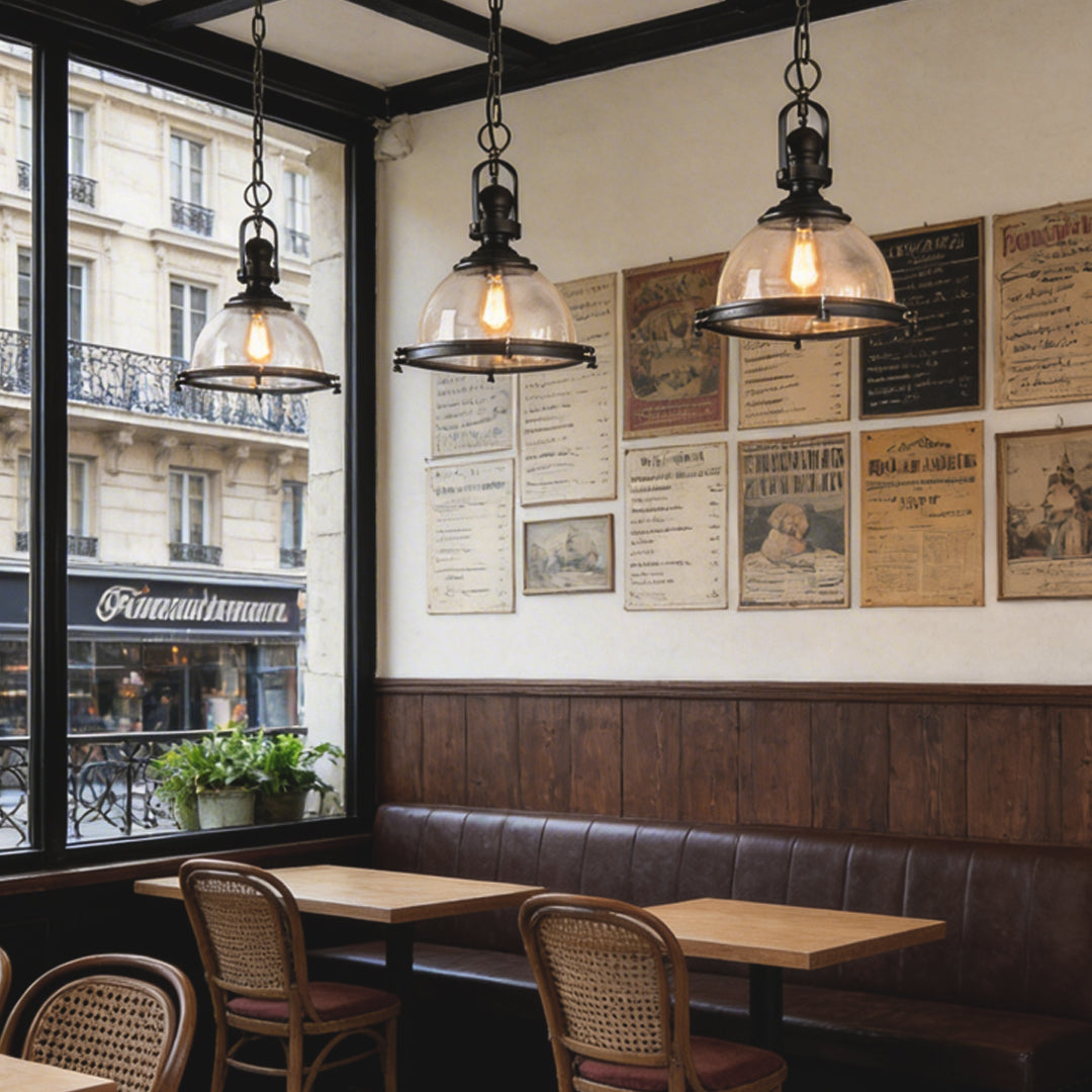 Glass pendant lights kitchen installed near large windows in a cozy bistro-style interior.