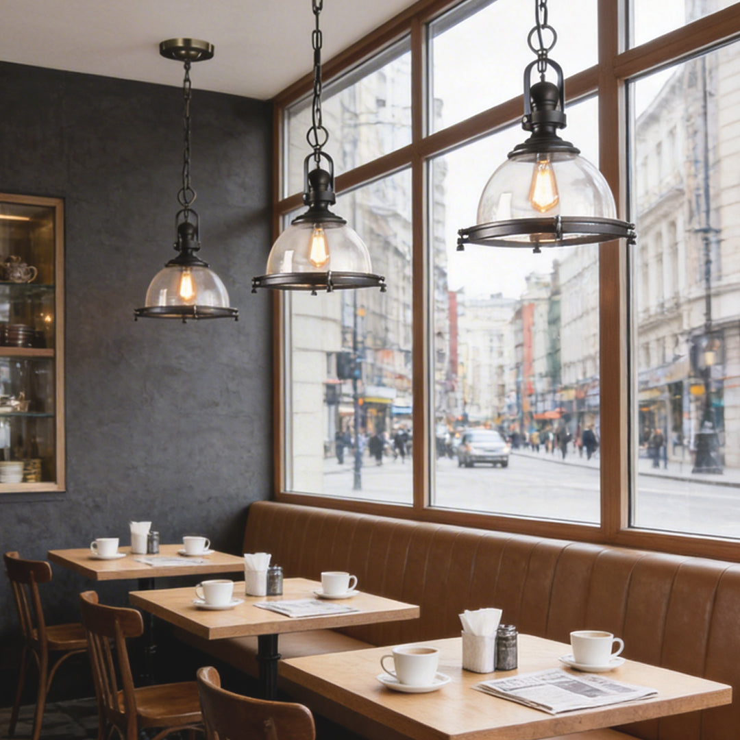 Glass pendant lights kitchen hanging above café-style tables creating a warm and inviting dining atmosphere.