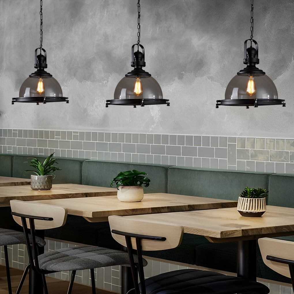 Glass pendant lights kitchen aligned over a long dining table in a contemporary restaurant setting.
