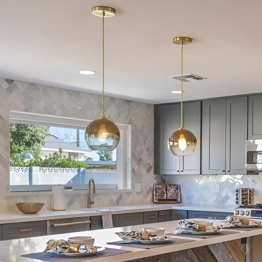 Glass round pendant light installed above a modern kitchen island.
